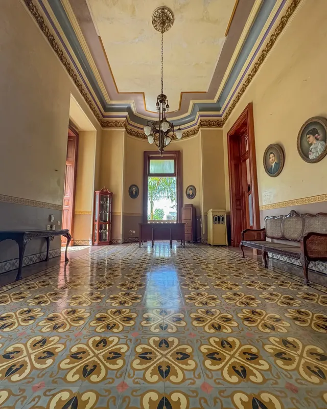 Salón con candil, techo decorado y piso de pasta