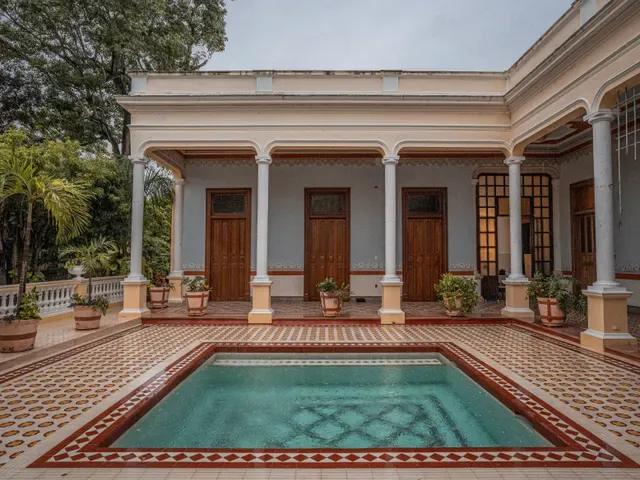 Alberca del Área Central frente al corredor con columnas y puertas de madera de Casona Cicero