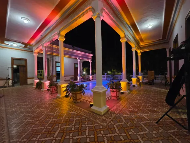 Corredores del Área Central de Casona Cicero iluminados en rosa y dorado durante un evento nocturno