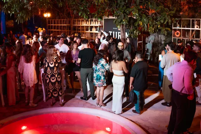 Invitados conversando durante un evento nocturno en el jardín de Casona Cicero